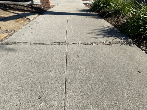 worn concrete sidewalk that needs repair.