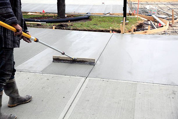 Man brushing concrete driveways for slip resistance and better traction.